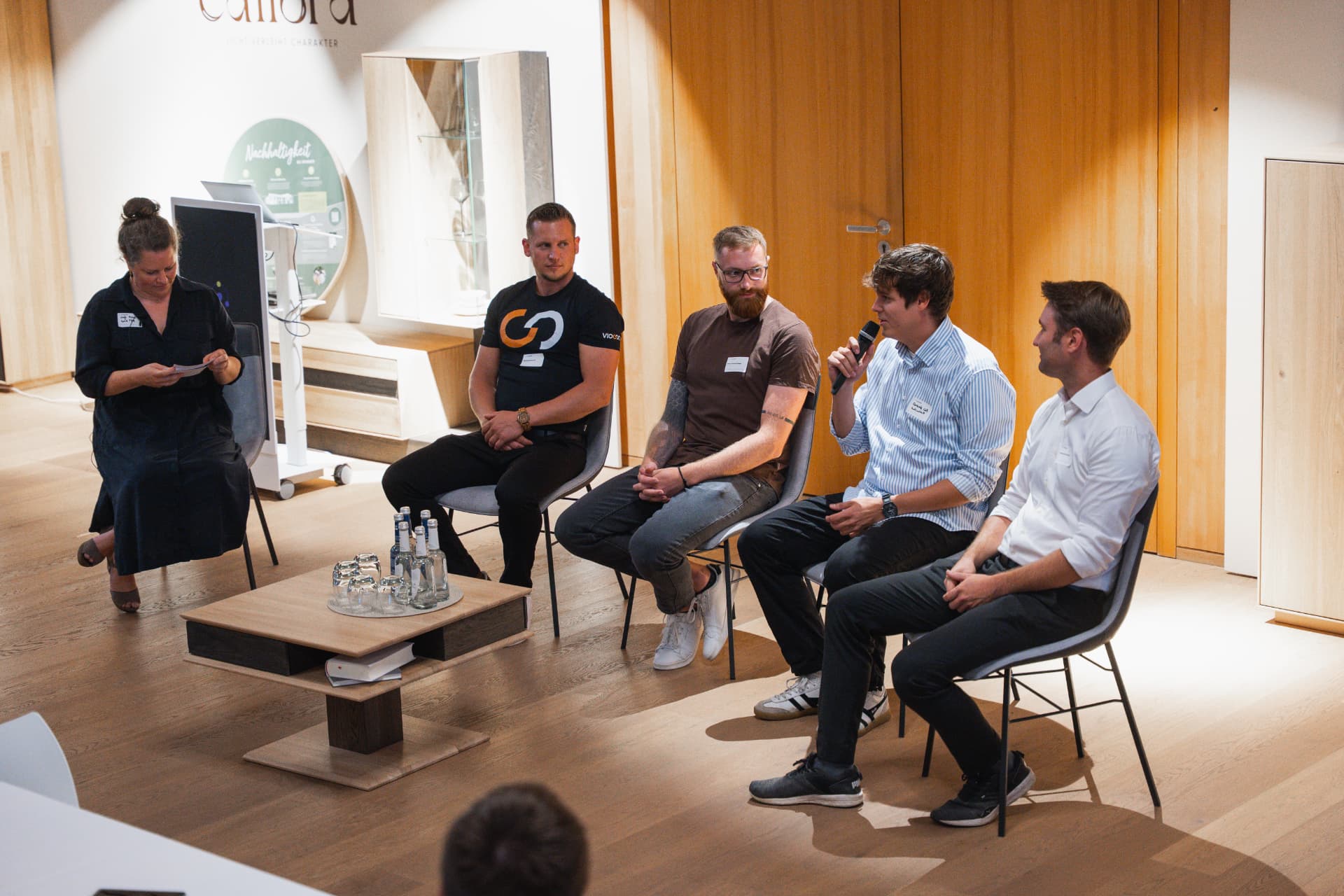 Diskussionsrunde auf der Bühne mit Moderatorin und vier Speakern