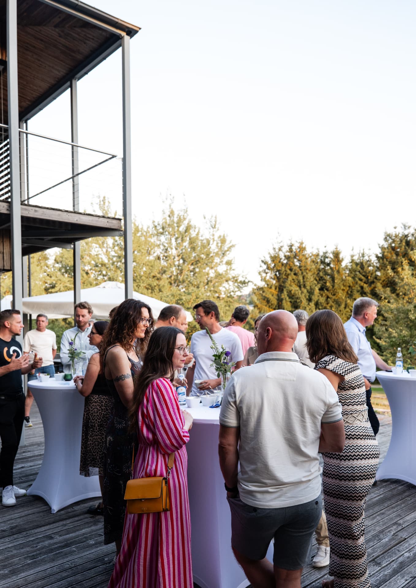 Networking an Stehtischen im Abendlicht